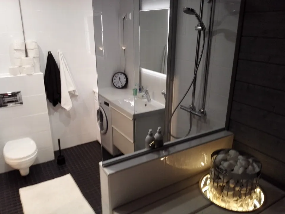 Kylpyhuoneessa on wc, pesukone, suihku ja kivikori.