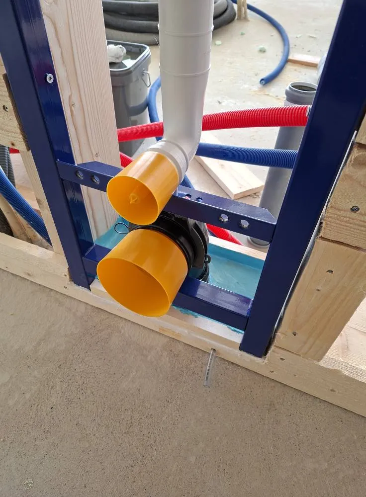 Lähikuva rakennustelineistä, joissa on muoviputkia, sininen metallirunko ja puinen kehys, valaistus on kirkas.